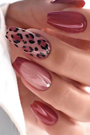 Obroi Close-up of a hand with maroon and leopard print nail designs.