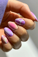 Hand with pink and purple nail polish on a neutral background, Obroi