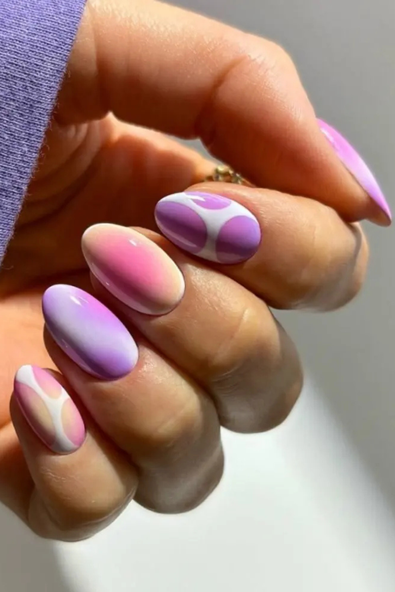 Hand with pink and purple nail polish on a neutral background, Obroi