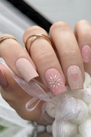 Obroi Close-up of a hand with pink nail art and decorative ribbons.