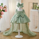 Green children's dress with a large bow on a mannequin against a neutral background