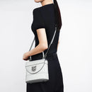 Person holding a white handbag with 'Obroi' branding on a plain background
