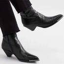 Black leather ankle boots worn with black pants on a light gray background, Obroi