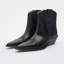 Pair of black leather cowboy boots on a light gray background, Obroi