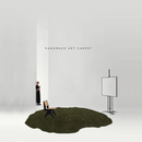 Handmade art carpet displayed in a minimalistic room with a person and chair, Obroi