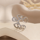 Silver ring with diamond accents on a beige surface, Obroi