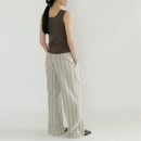 A woman shown from the back wearing a sleeveless dark brown top and wide-leg striped pants in beige and gray, standing against a plain light background, Obroi