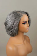 A short, wavy gray wig with a side part, displayed on a mannequin head against a plain beige background, Obroi