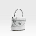 Silver handbag with a cat emblem on a white background, featuring the brand 'Obroi'.