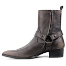 A dark brown leather ankle boot with a side zipper, a decorative strap across the instep with metal rivets, and a low block heel, shown against a plain white background, Obroi