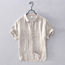 Beige linen shirt on a hanger against a gray background, Obroi