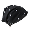 A black slouchy beanie hat decorated with multiple silver rhinestone studs and featuring a silver metal grommet at the bottom, shown on a plain white background, Obroi