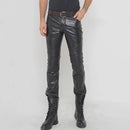 Person wearing black leather pants and black boots on a white background