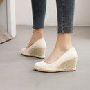 White wedge sandals with jute sole worn with blue jeans on a neutral background, Obroi
