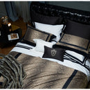 Bed with patterned bedding and pillows in a bedroom setting, Obroi