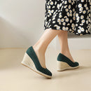 Green wedge sandals worn with a floral dress on a neutral background, Obroi