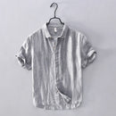 Striped shirt on a hanger against a plain background, Obroi