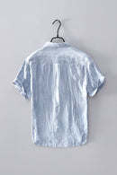 Light blue short-sleeve shirt on a hanger against a gray background, Obroi