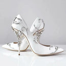 White high-heeled shoes with decorative designs on a light gray , Obroi background