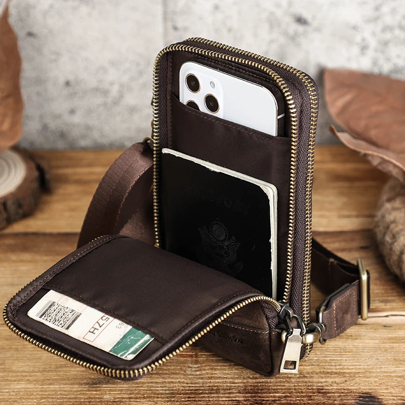 Brown leather crossbody bag with compartments on a wooden surface