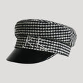 Black and white checkered cap with a black visor on a light gray background, Obroi