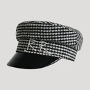 Black and white checkered cap with a black visor on a light gray background, Obroi