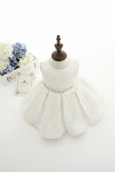 White lace dress on a mannequin with flowers in the background, Obroi