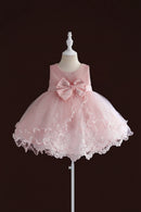 A sleeveless pink party dress with a large bow at the waist, displayed on a stand against a dark brown background, Obroi