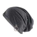 A dark gray slouchy knit beanie hat featuring a silver-tone metal O-ring hanging from the side, shown against a plain white background, Obroi