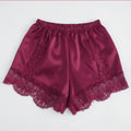Red satin shorts with lace trim on a white background, Obroi