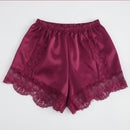 Red satin shorts with lace trim on a white background, Obroi