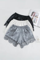 Black top and gray shorts with lace details on a white surface, Obroi