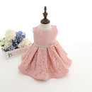 Pink lace dress on a mannequin with flowers in the background, Obroi