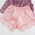 Pink satin shorts with lace trim on a light gray background, Obroi
