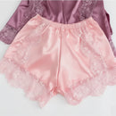Pink satin shorts with lace trim on a light gray background, Obroi