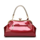 Shiny red handbag with gold accents on a white background, Obroi