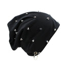 A black slouchy beanie hat decorated with multiple silver metal spikes and studs, featuring a silver metal grommet and ring at the bottom, shown on a plain white background, Obroi