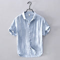 Light blue striped shirt on a hanger against a gray background, Obroi