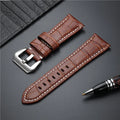 Brown leather watch strap with silver buckle on a dark surface, Obroi