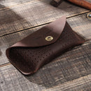 Brown leather tool pouch with perforated design on a wooden surface, Obroi