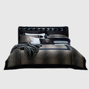 Obroi home collection bed with dark patterned comforter and pillows on a light background, Obroi