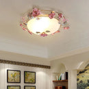 Ceiling light fixture with floral design in a room with wall art and shelves, Obroi