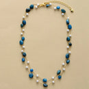 Necklace with blue beads and pearls on a beige background, Obroi
