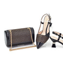 Black clutch bag with gold chain and black high-heeled shoes on a white background, Obroi