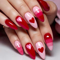 Nails with red and pink gradient design and heart shapes on a neutral background, Obroi