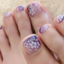 Obroi Close-up of toes with purple nail polish and floral design on a light background