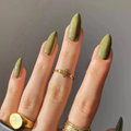 Hand with olive green nails and gold rings on a neutral background, Obroi