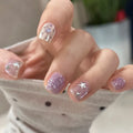 Close-up of a hand with pink glittery nails and star designs, Obroi