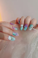 Close-up of a hand with colorful glittery nail art on a light background, Obroi