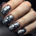 Nails with black and white floral design on a dark background, Obroi